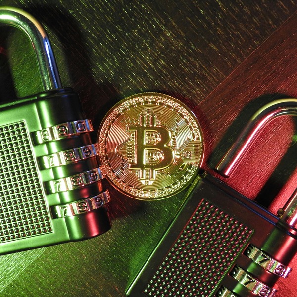Bitcoin coin with a padlock on a keyboard
