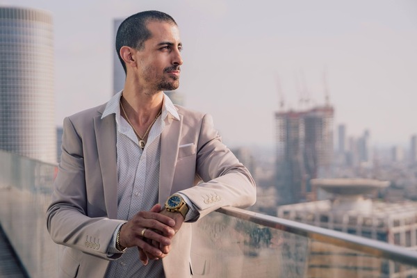 Businessman checking his watch on a city balcony