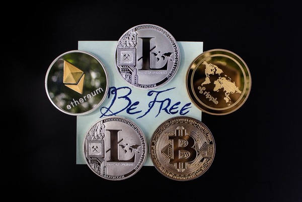 Crypto coins arranged around a Be Free note