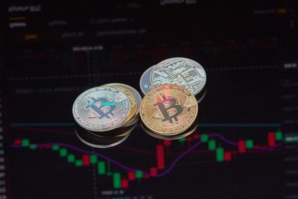Crypto coins stacked over a candlestick chart