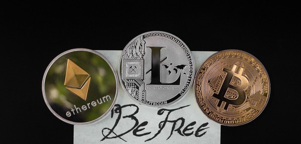 Ethereum, Litecoin and Bitcoin coins with a Be Free note