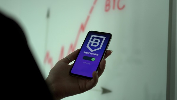 Hand holding a smartphone with a crypto wallet app