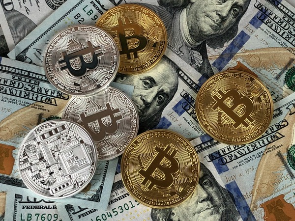Silver and gold Bitcoin coins on banknotes