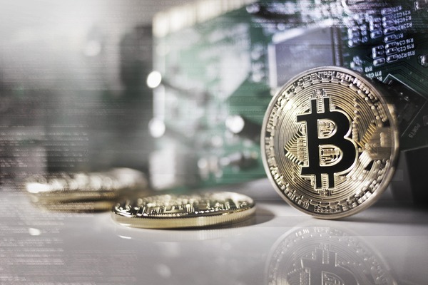 Silver Bitcoin coins in front of a server rack
