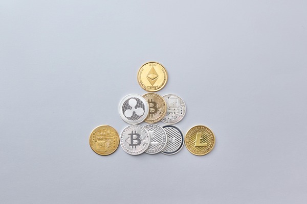 Small pyramid of crypto coins on a grey background